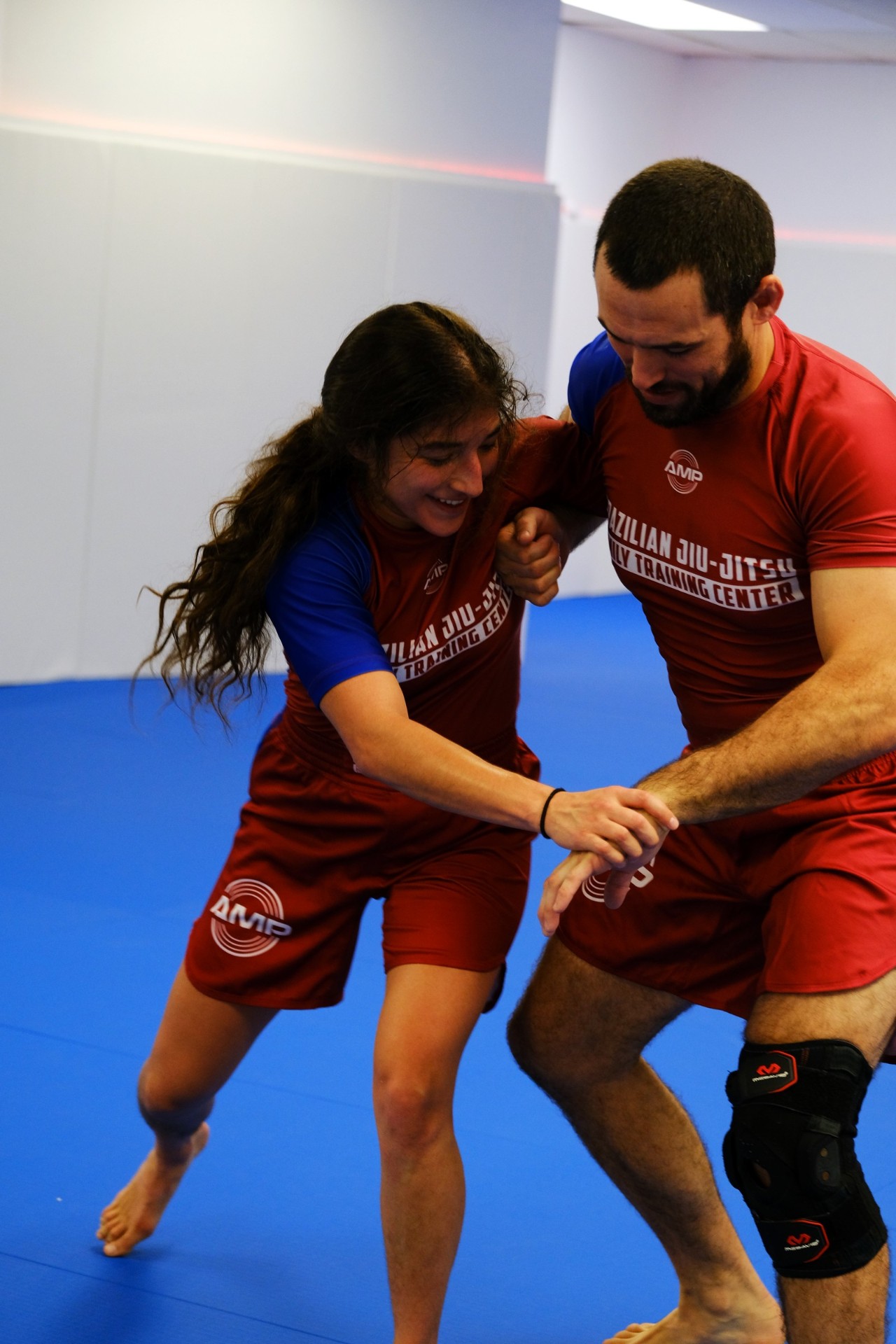 Two AMP BJJ coaches drilling a takedown on the mat