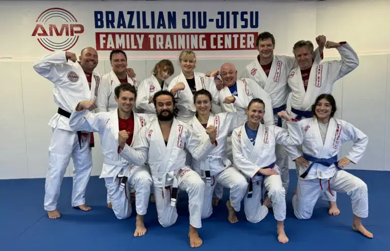 MP BJJ adult students and instructors flexing in their white gis, celebrating strength, camaraderie, and growth at the Family Training Center.